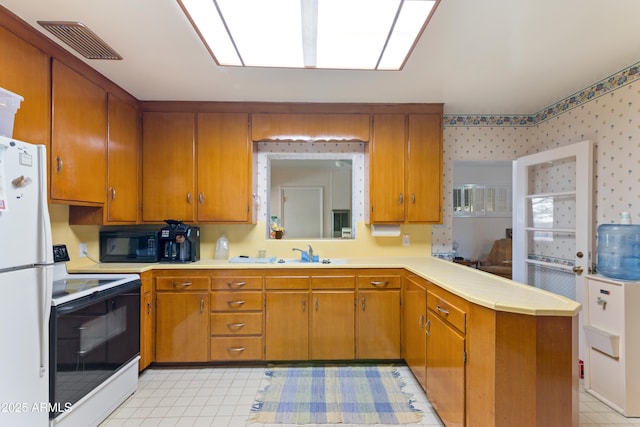 kitchen featuring sink, white appliances, and kitchen peninsula