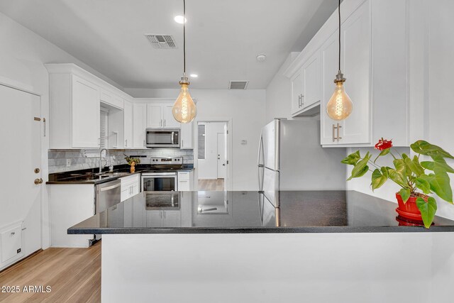 1306 E Fillmore St, Phoenix, AZ 85006 - kitchen featuring appliances with stainless steel finishes, white cabinetry, a peninsula, decorative backsplash, and recessed lighting