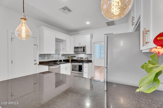 1306 E Fillmore St, Phoenix, AZ 85006 - kitchen with stainless steel appliances, white cabinets, decorative backsplash, a sink, and recessed lighting