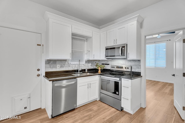 1306 E Fillmore St, Phoenix, AZ 85006 - kitchen with stainless steel appliances, a sink, dark countertops, and white cabinetry