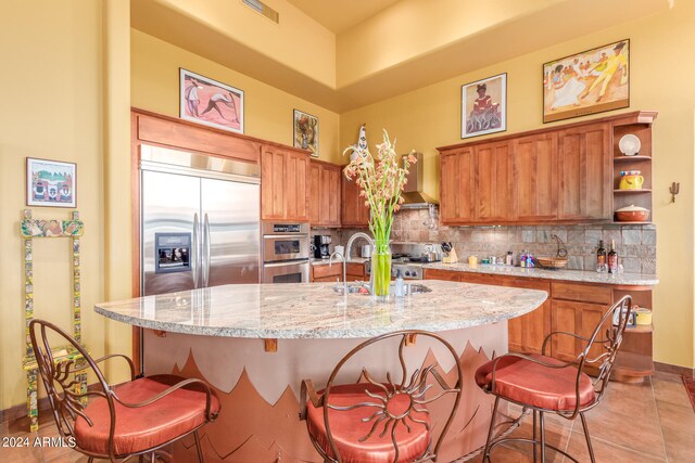 kitchen with brown cabinets, visible vents, and wall chimney range hood