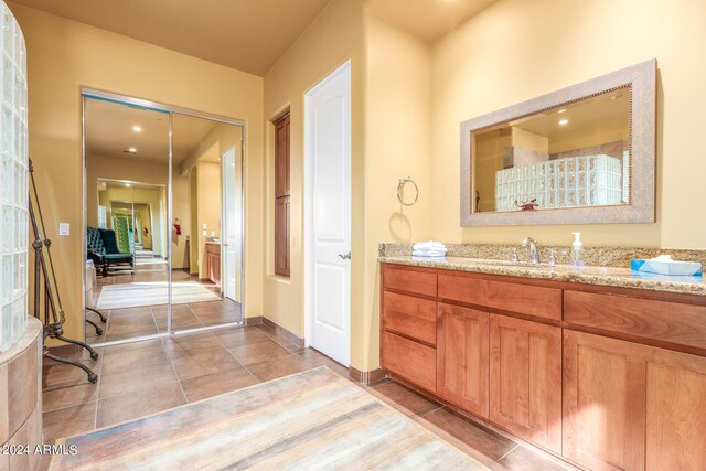 bathroom with tile patterned flooring, vanity, and baseboards