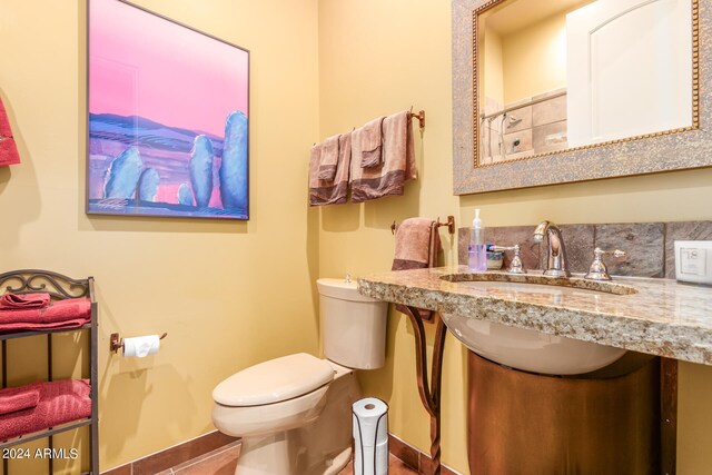 bathroom featuring tile patterned floors, a sink, toilet, and baseboards