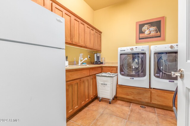 washroom with cabinet space, light tile patterned flooring, a sink, and washer and clothes dryer