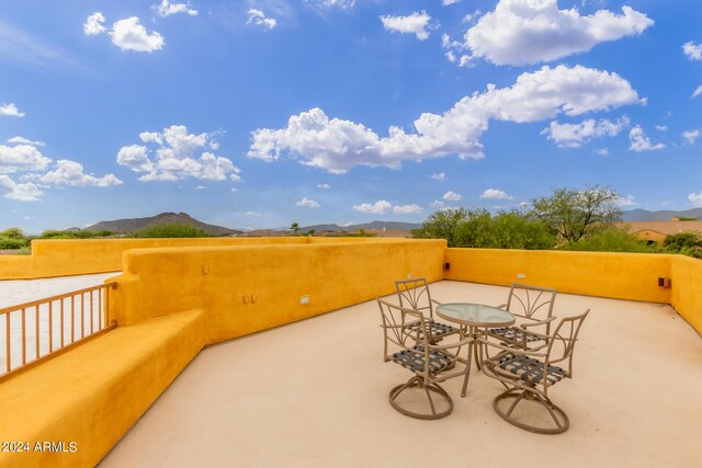 view of patio / terrace featuring a balcony, a mountain view, and outdoor dining area