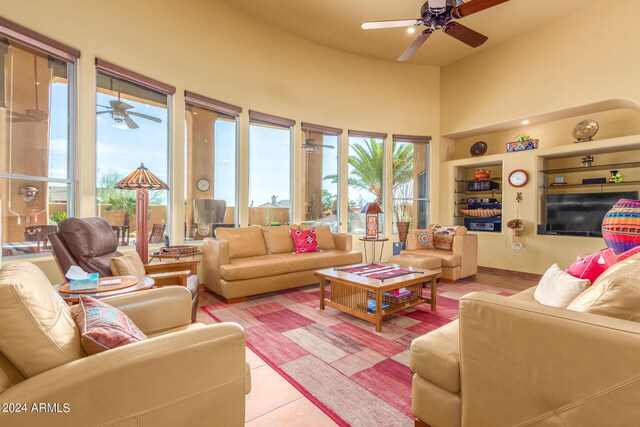 living room featuring ceiling fan and a high ceiling