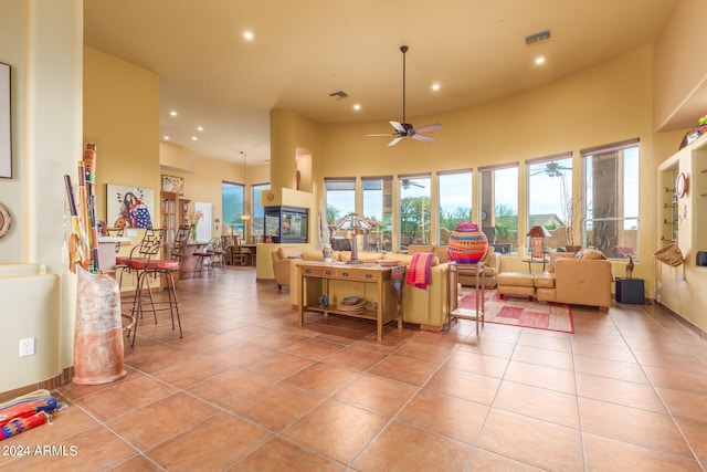 living area with recessed lighting, a high ceiling, visible vents, and light tile patterned flooring