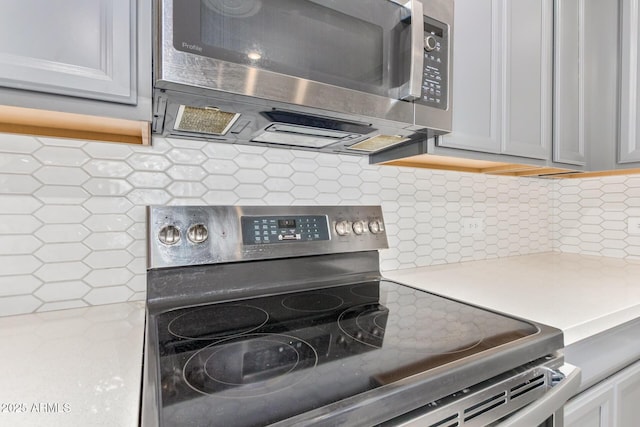 kitchen featuring appliances with stainless steel finishes, light countertops, and backsplash