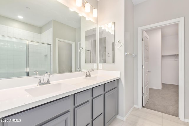 full bathroom with a sink, a shower stall, baseboards, and double vanity