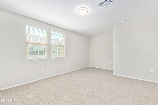 unfurnished room featuring baseboards, visible vents, and carpet flooring