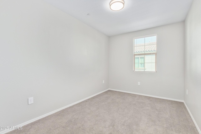 unfurnished room featuring carpet and baseboards