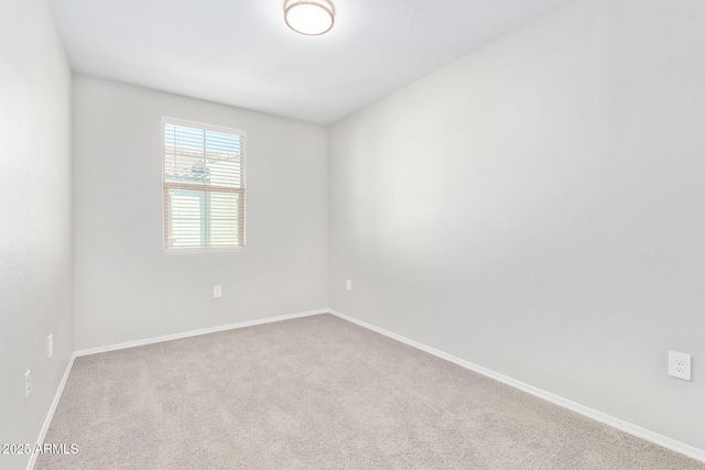 carpeted empty room with baseboards