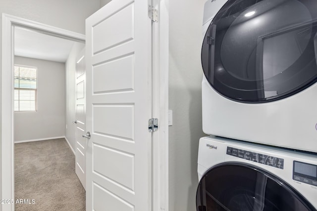 laundry room with stacked washer and dryer, carpet floors, laundry area, and baseboards