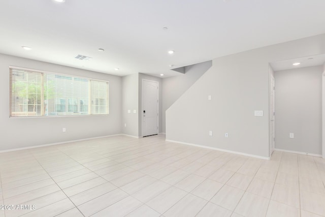 unfurnished room with baseboards, visible vents, and recessed lighting