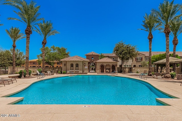 community pool with a gazebo, a patio, and fence