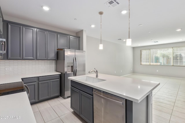 kitchen with tasteful backsplash, visible vents, appliances with stainless steel finishes, open floor plan, and a sink