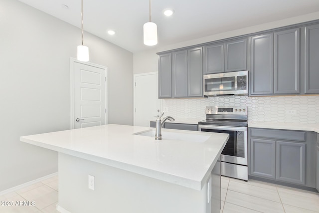 kitchen featuring decorative backsplash, gray cabinets, stainless steel appliances, a sink, and light tile patterned flooring