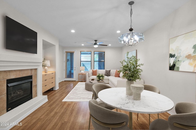 dining area with hardwood / wood-style flooring and ceiling fan with notable chandelier