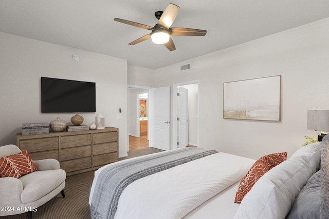 bedroom with connected bathroom, ceiling fan, and hardwood / wood-style flooring