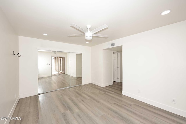 unfurnished bedroom featuring a closet, wood-type flooring, and ceiling fan