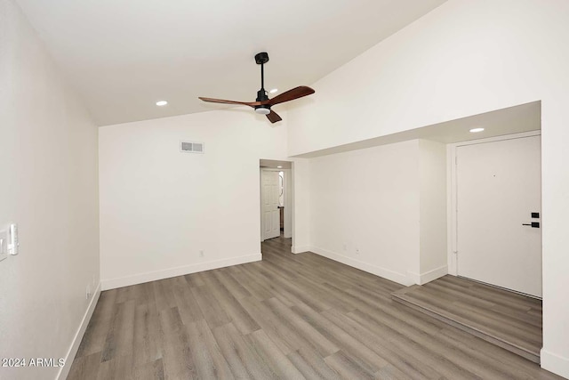 unfurnished room featuring high vaulted ceiling, baseboards, ceiling fan, visible vents, and wood finished floors
