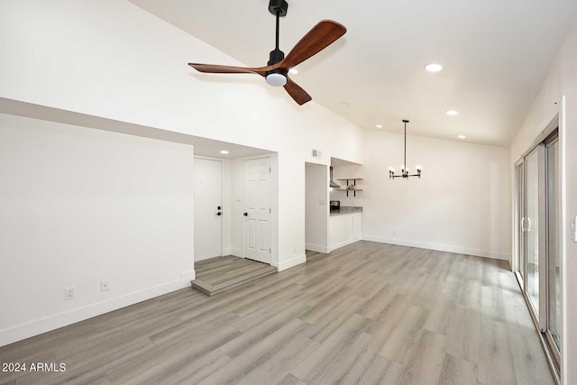unfurnished living room with ceiling fan with notable chandelier, baseboards, light wood finished floors, and recessed lighting