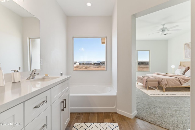 11263 E Crescent Ave, Mesa, AZ 85208 - ensuite bathroom with vanity, a garden tub, wood finished floors, a ceiling fan, and baseboards