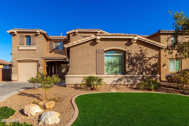 mediterranean / spanish home featuring a front yard and a garage