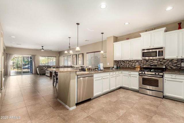 kitchen with decorative light fixtures, ceiling fan, appliances with stainless steel finishes, and white cabinetry