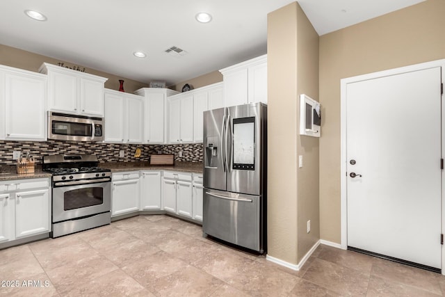 kitchen featuring backsplash, appliances with stainless steel finishes, dark stone countertops, and white cabinetry