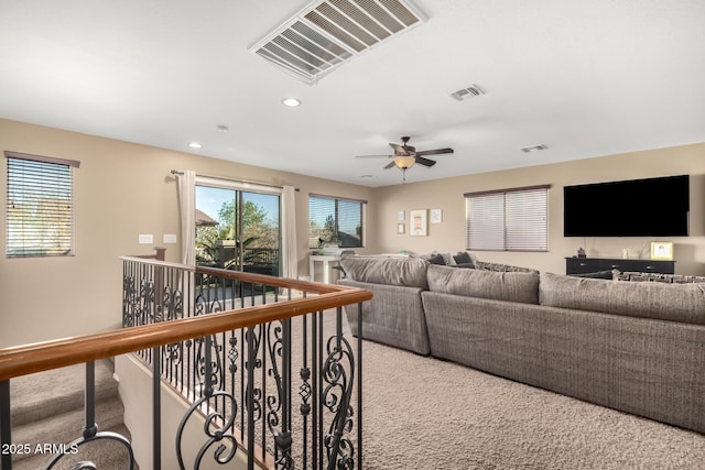 carpeted living room with ceiling fan