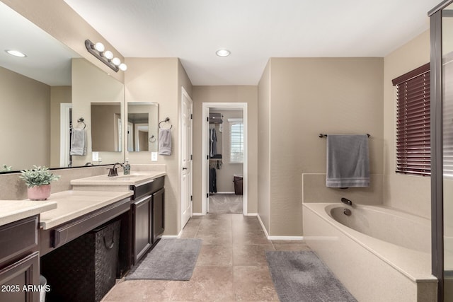 bathroom with vanity, a tub, and tile patterned floors