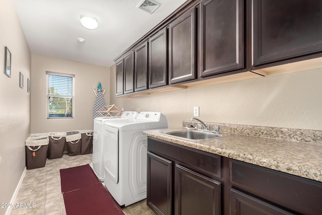 laundry area featuring cabinets, sink, and separate washer and dryer