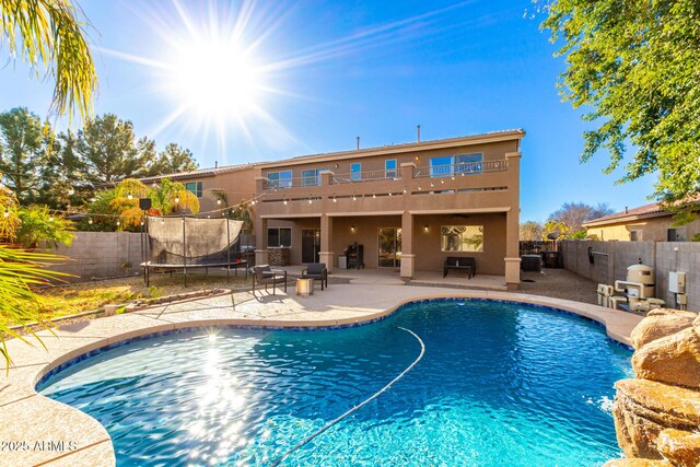 view of swimming pool with a trampoline and a patio