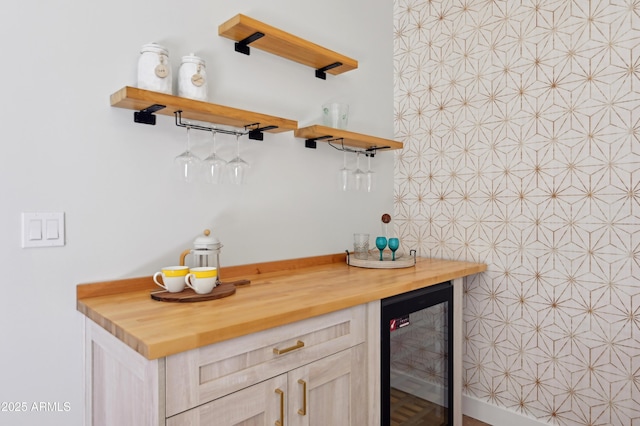 bar with light brown cabinetry, butcher block countertops, and beverage cooler