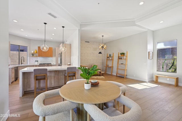 dining area featuring a notable chandelier and light wood-type flooring