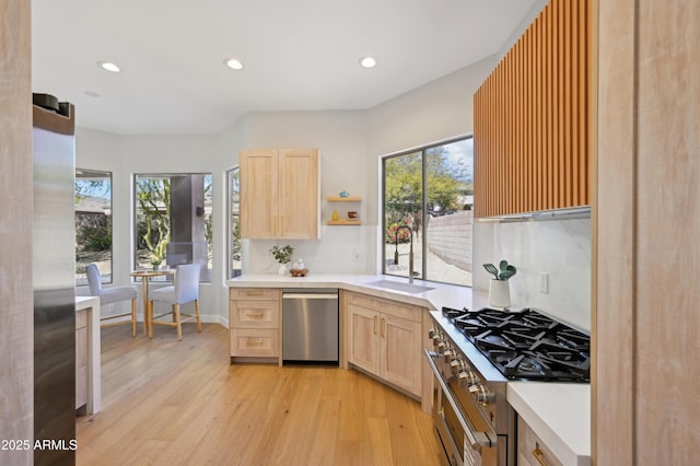 kitchen featuring sink, light hardwood / wood-style flooring, light brown cabinets, and appliances with stainless steel finishes