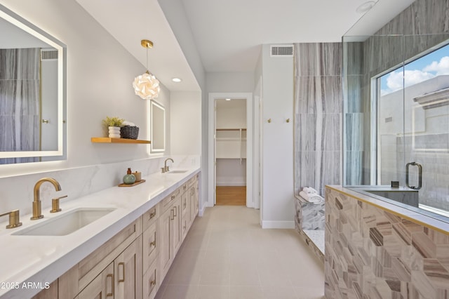 bathroom featuring vanity, a shower with shower door, and tile patterned floors