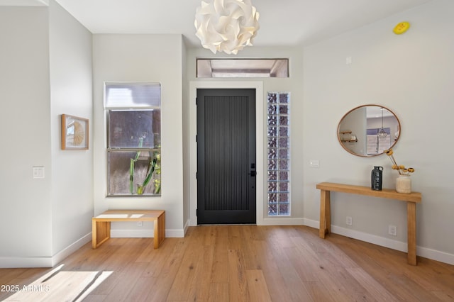 entryway with an inviting chandelier and light wood-type flooring