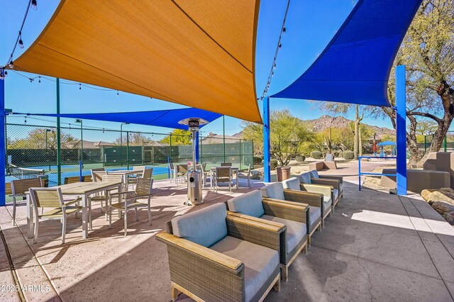 view of patio / terrace with a mountain view and tennis court