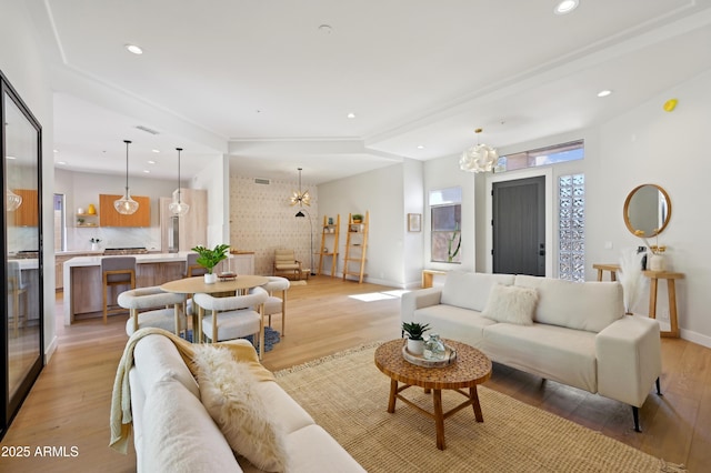 living room with a notable chandelier and light hardwood / wood-style flooring