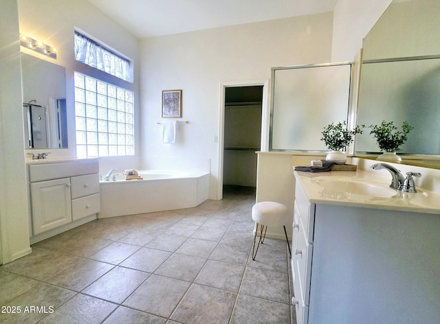 bathroom featuring a sink, a stall shower, a bath, tile patterned flooring, and two vanities