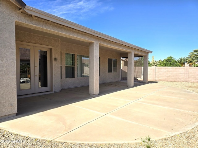 view of patio with french doors and fence