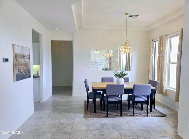dining room with a chandelier, visible vents, and baseboards
