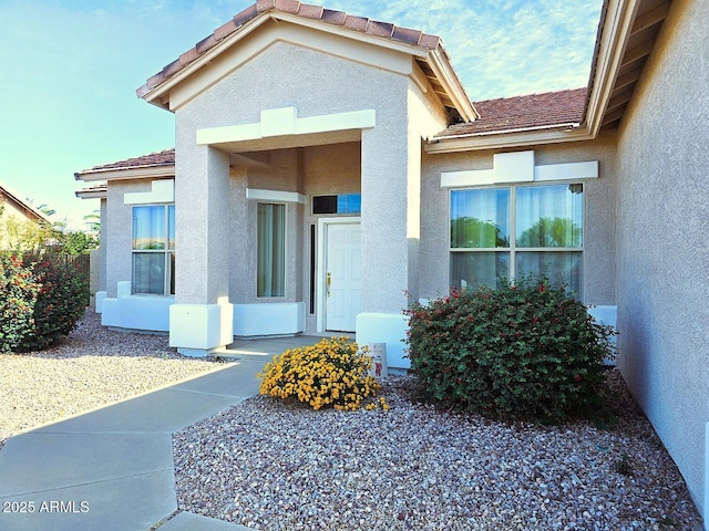 entrance to property featuring stucco siding