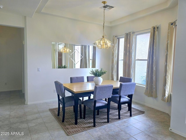 dining room with plenty of natural light, a notable chandelier, and a raised ceiling