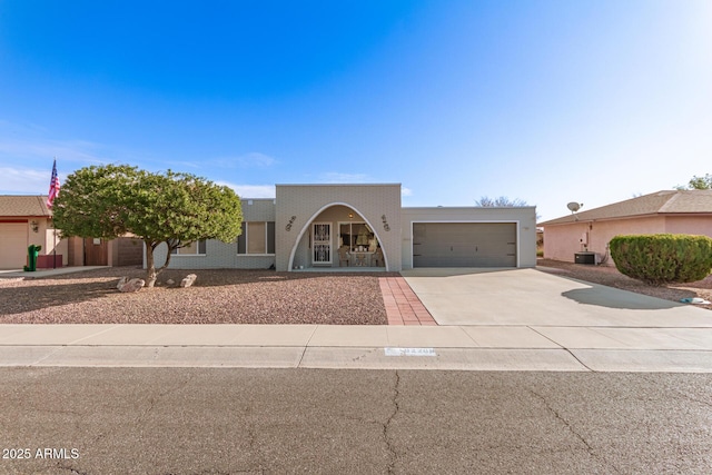 adobe home with central AC unit and a garage