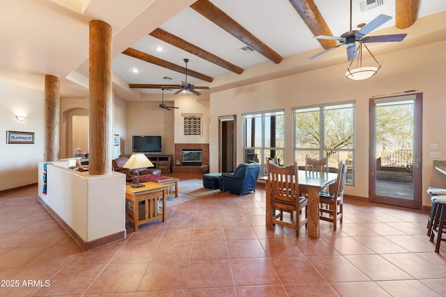 dining room featuring light tile patterned flooring, a fireplace, beam ceiling, and baseboards