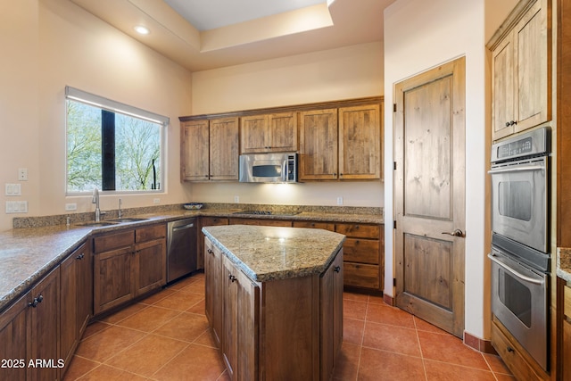 kitchen featuring stainless steel appliances, a sink, a center island, and tile patterned floors