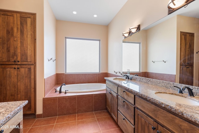 bathroom with tile patterned flooring, double vanity, a sink, and a bath